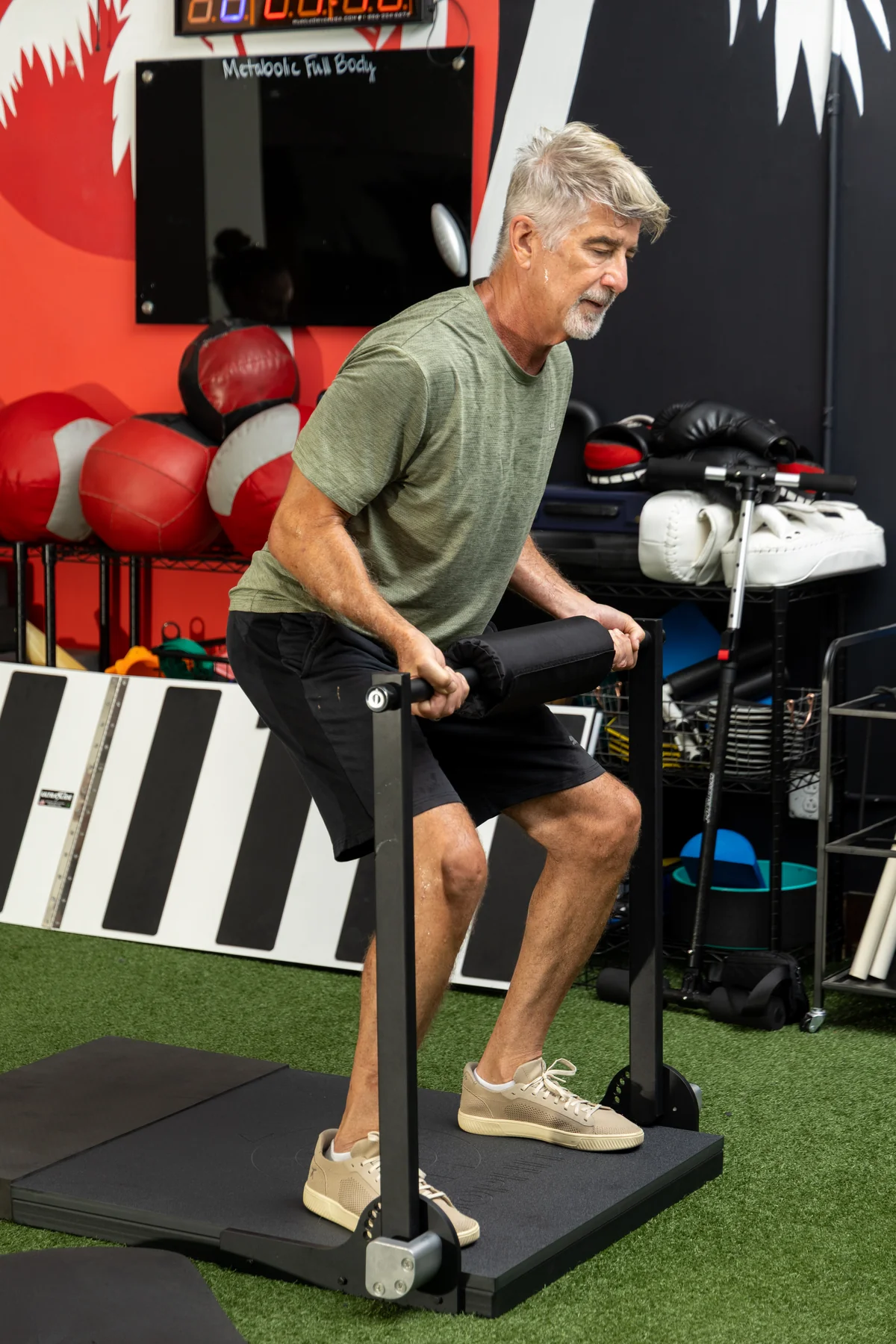 Adult performing a coached ISOPHIT strength exercise at Primal Fit Miami