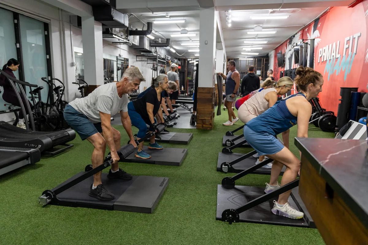 Adults 50+ performing coached ISOPHIT strength training at Primal Fit Miami
